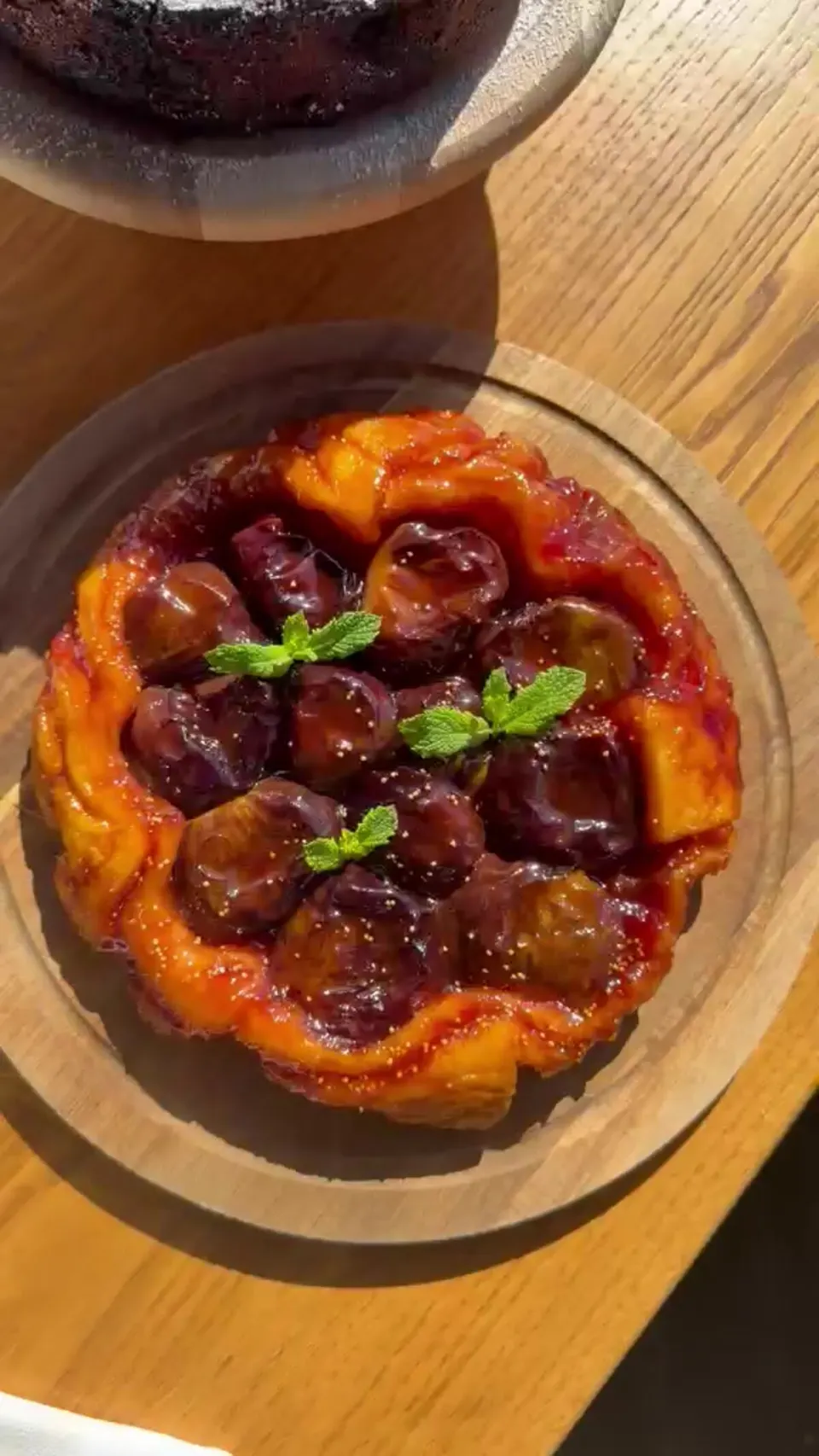 La tarte tatin alle prugne servita su un tagliere di legno